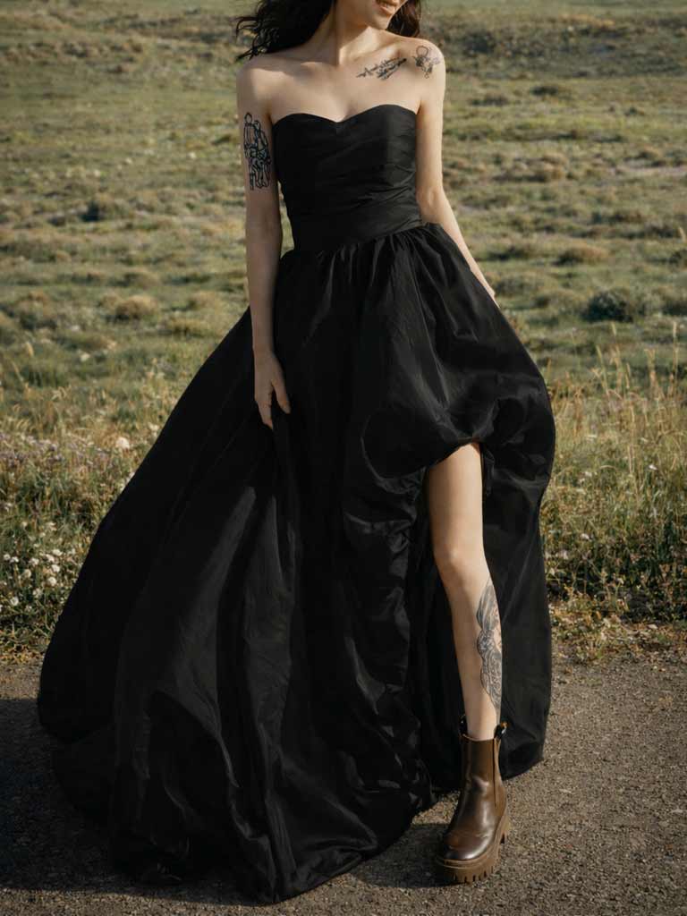 Modernes schwarzes Brautkleid mit Beinschlitz und Korsage-Oberteil, ideal für urbane Hochzeiten in der Schweiz.